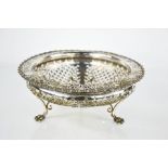 A silver fruit bowl with pierced decoration, raised on three claw feet, retailed by Hancocks & Co,