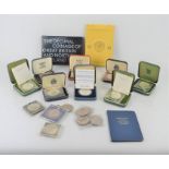 A group of commemorative coins to include some silver proof examples in original cases