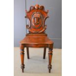 A 19th century mahogany hall chair with C' scrolls and foliate swags, 88cm height