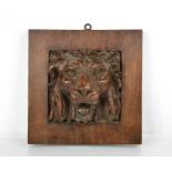 A 19th century carved oak panel depicting a protruding lion head, 19 by 19cm.