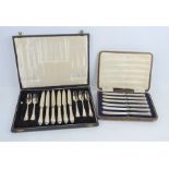 A cased set of silver handled butter knives together with a cased set of cake knives and forks,