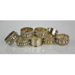 Eight silver and white metal napkin rings, including two 19th century machine engraved examples.