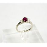 A platinum, ruby (0.88ct) and diamond (0.36ct) three stone ring, size L, 4.3g.