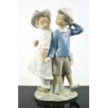 A Lladro porcelain figure group titled Puppy Love; boy and girl holding hands, number 1127, 25cm