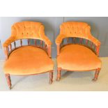 Two Victorian tub chairs upholstered in gold draylon, the arms having shaped supports with turned