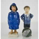 A Royal Copenhagen child in a blue raincoat numbered 532 to the base, together with a Denmark boy