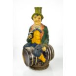 An Italian Vermouth Torino glass bottle in the form of a man sat on a barrel, embossed Brew 31507,