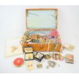 A wooden and metal clad jewelry box containing a selection of vintage jewelry, brooches, bracelets,