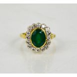 An 18ct gold, emerald and diamond ring, the oval cut emerald approximately 3cts, surrounded by