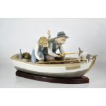 A Lladro porcelain group titled Fishing with Gramps, on a boat named Paloma, with wooden stand.