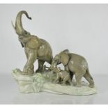 A Lladro porcelain group titled Elephants Walking, 37cm high.