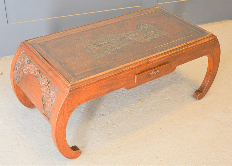 A Chinese carved coffee table, with figural scene to top, single drawer to front, 42cm high by