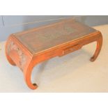 A Chinese carved coffee table, with figural scene to top, single drawer to front, 42cm high by