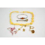 A silver and amber bangle, a bone carved necklace, gilt metal charm, necklaces and a Scottish dirk