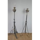 Two early 20th century paraffin lamps raised on cast stands, height adjustable