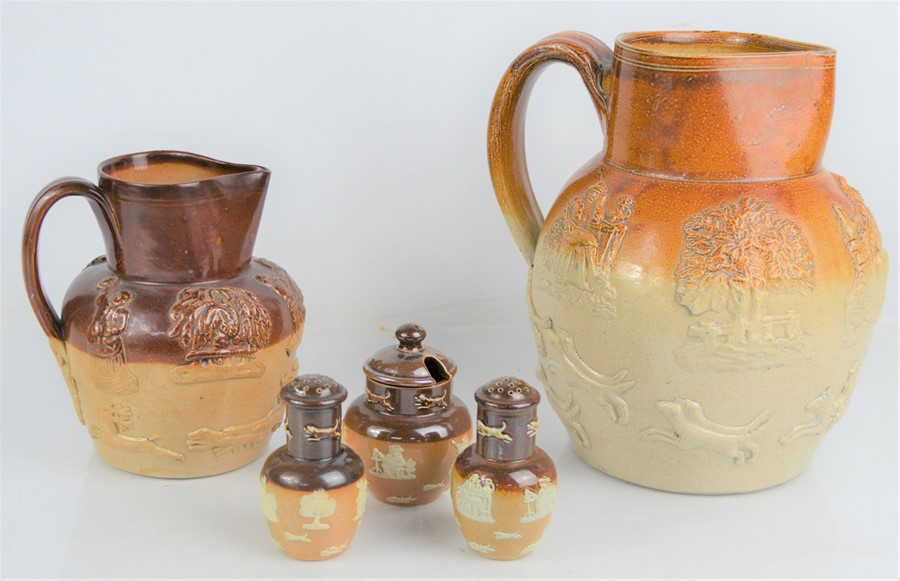 A 19th century treacle glaze pitcher and jug with relief moulded decoration of horse and hounds