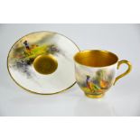 A Royal Worcester cabinet cup and saucer, by JAS Stinton, painted with pheasants in a landscape with