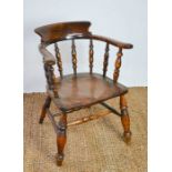 A 19th century elm smokers bow armchair, with turned spindles.