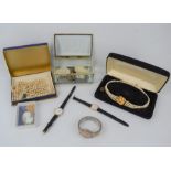 A group of vintage costume jewellery to include two pearl necklaces, brooches, a glass jewellery box