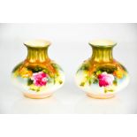 A pair of Royal Worcester squat vases, painted with pink / yellow roses and gilded highlights, circa