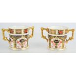 A pair of Royal Crown Derby Imari 1128 pattern loving cups with twin handles, 8cm high.