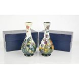 A pair of Moorcroft vases, with the original boxes, signed J Moorcroft to the bases.