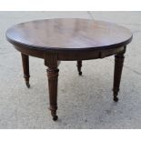 A late 19th century mahogany dining table raised on tapering fluted legs and brass castors, with