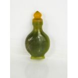 A Chinese Heitian green jade hand carved snuff bottle and stopper.