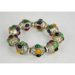 A Chinese Tibetan carved Miao silver bangle inset coloured jade cabochons.