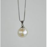 A baroque pearl pendant silver white metal chain.