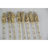 A set of eight Chinese Tibetan Miao silver tea spoons, figural scholars with bamboo design stems,