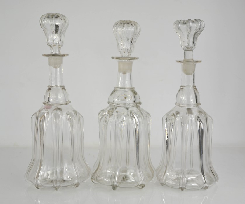 Three moulded glass decanters with stoppers.