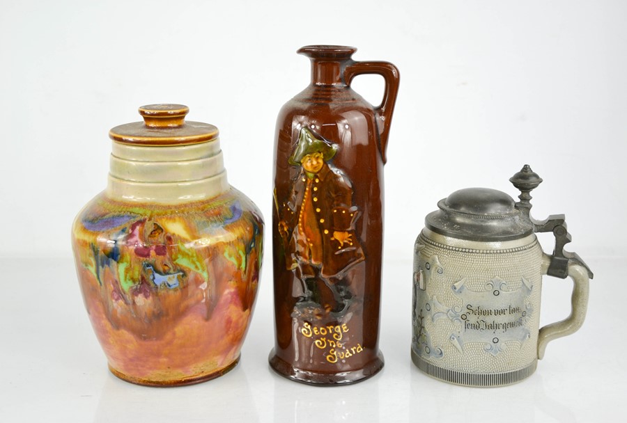 A Doulton bottle depicting George One Guard, a Doulton jar & cover and a German stein with pewter