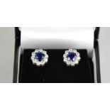 A pair of 18ct white gold, blue sapphire and diamond cluster earrings, the sapphires totalling 1.2ct