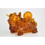 A large vintage Chinese hand carved amber snuff bottle and stopper in the form of dragon and pearl.