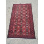 A red ground rug with diamond shape pattern, 98cm by 178cm