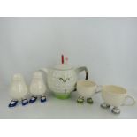 A Carlton ware salt and pepper and similar cups and a Tony Wood novelty golf ball teapot