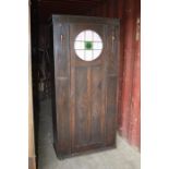 A vintage oak wardrobe with glass roundel to the door.