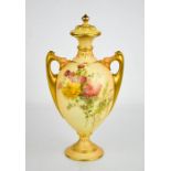 A Royal Worcester blush ivory vase and cover, painted with flowers all over with finialled lid and