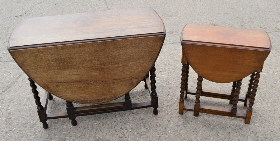 An oak drop leaf dining table together with a smaller example