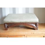 A gothic style footstool with upholstered top