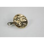 An early silver medallion depicting a shepherdess and sheep, 2.5cm diameter, hoop and link to back.