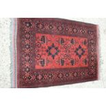 A red ground rug with Aztec design, 105cm by 142cm