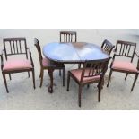 A Victorian oval extending dining table with ball and claw feet together with six dining chairs,