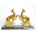 A pair of Art Deco spelter leaping deer book ends, gilded and cold painted, raised on black and