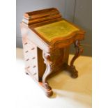 A Victorian walnut davenport with green leather writing slope with inlaid cupboard and stationary