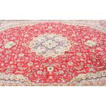 A large Middle Eastern carpet, with central red ground, with borders of cream and ochre, and