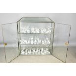 A glass display cabinet, together with a group of Swarovski crystal animal figures, of various