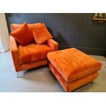 A designer armchair and matching footstool, with two cushions, upholstered in orange velvet.