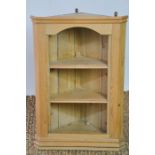 An antique pine corner cabinet with two shelves and shaped apron.42 by 25 by 66cm.